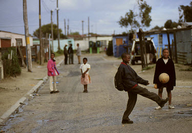 Children play football in the streets of Khayelitsha Township.