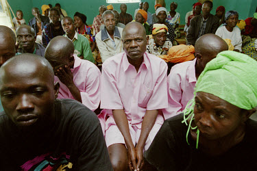Prisoners (in pink) attend a Gacaca trial. Gacaca is a traditional form of jurisdiction, now used to try participants of the 1994 genocide. It is a nationwide justice project based on a Rwandan tradit...