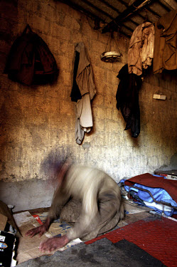 A worker prays in his quarters at the ship-breaking yard in Gaddani.