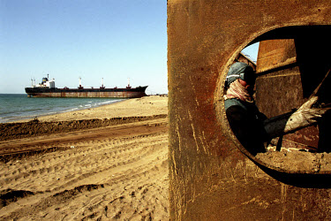 A worker at the Gaddani ship-breaking yard labours on a part of a ship. In the days when Gaddani was still in full operation it wasn't uncommon to find hundreds of ships here, all waiting to be broken...
