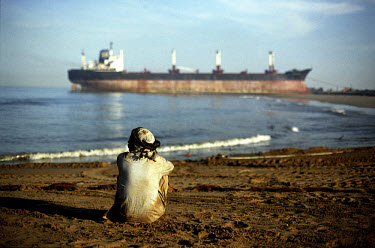 A worker rests on the beach beside the ship-breaking yard in Gaddani.