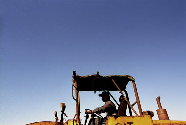 A worker at the Gaddani ship-breaking yard driving a tractor. For around USD 1.20 a day, thousands of workers labour to dismantle dozens of ships each year.