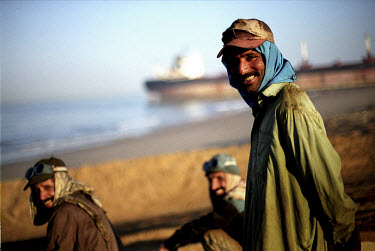 Workers from the Gaddani ship-breaking yard take a break on a nearby beach.