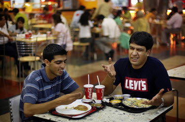 Muqaddas Bashir, left, and Shahid Bakshi eat Indian fast food called Paranthas at the PVR Spice Mall. As new processed foods have become available to wealthy and upper middle class Indians obesity rat...