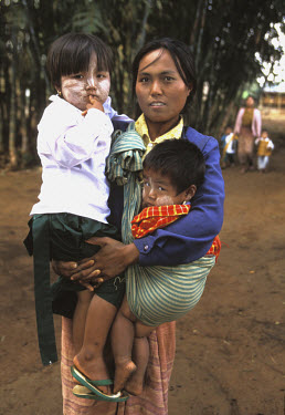 A mother brings two of her children to the Save the Children Fund's preschool at Oak Tha Kan village, Shan State. The children have 'tanaka' on their face, a natural sun-block made from the bark and w...