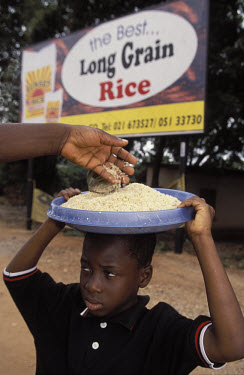 A boy sells rice at a roadside in Accra.