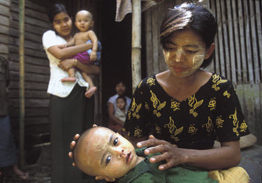 Traditional 'tanaka' is applied to a baby's face in Khat-Tu village. Tanaka is believed to be good for the skin and keep away germs and evil spirits. Many Burmese women and children wear tanaka, a nat...