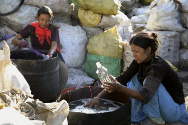 Women washing bottles at a glass recycling centre.
