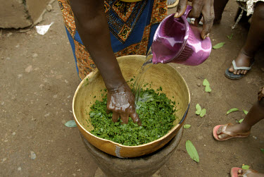 Mother of a pregnant woman prepares medicine from leaves to try to bring on her daugher's labour, in Freetown's Kroo Bay slum, which has the world's worst infant and maternal mortalitly rate. One in f...