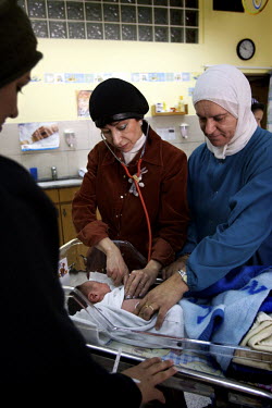Dr Ella Sela (Jewish, 45, Paediatric Doctor), with Maha Mousa (Muslim nurse) assisting, does her rounds checking all newly delivered babies. Nazareth Hospital is staffed by Muslim, Christian and Jewis...