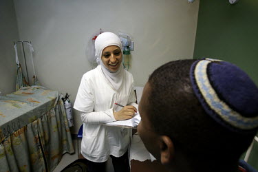20 year old Nurse Abeer Jabareen talks with a Jewish patient at the chest clinic. Nazareth Hospital is staffed by Muslim, Christian and Jewish doctors all working together despite religious and politi...