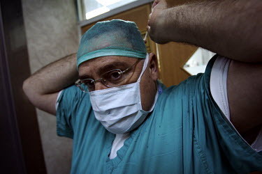 Henry Haddad (Head Anesthesiologist, Christian) attaches a surgical mask. Nazareth Hospital is staffed by Muslim, Christian and Jewish doctors all working together despite religious and political diff...