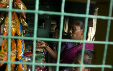 Kusum buys some biscuits for her daughter Sheetal as they travel to the Sangli Civil Hospital to receive their ARV (antiretroviral) drugs. Many people like Kusum travel from adjoining villages to the...