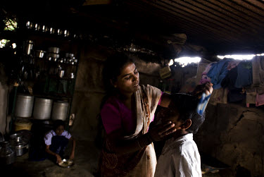 Kusum combs her middle son Ritesh's hair before school, as her eldest daughter Sheetal (who is HIV positive) finishes her breakfast. Kusum is a widow living with HIV. One of her children is also HIV p...