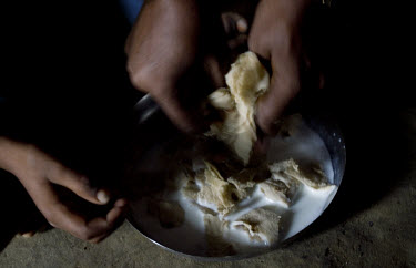 Kusum prepares breakfast for her youngest son Sudhir,  which comprises of one roti with goats milk. Kusum is a widow living with HIV. One of her children is also HIV positive, one is not, and the stat...