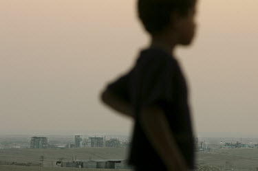 A child in the unrecognized Bedouin village of Wadi El-Na'am, with the chemical waste plant of Ramat-Chovav in the distance. Locals believe, as do environmentalists, that Ramat-Chovav is the reason wh...