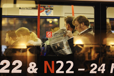 A man on an Edinburgh bus reading The Scotsman newspaper.