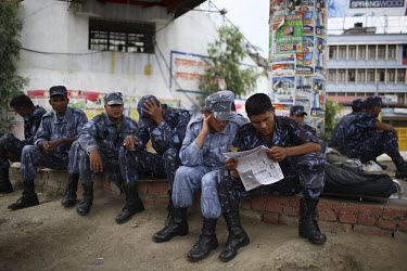 Police read a newspaper during a strike in Kathmandu.