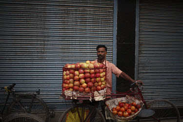 A street vendor selling apples and pomegranates on the street in Katmandu.