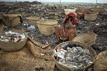 A woman rests while collecting rubbish for resale. At the end of each day, she earns TK 55 to 70 (USD 1). The Matuail Dump is one of three waste sites in Dhaka, a city of over ten million people. On a...