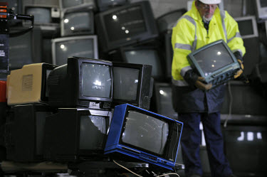 Council workers sorting old TVs for onward delivery to be eventually stripped down and recycled at Lowestoft Council Waste and Recycling Plant, Suffolk.