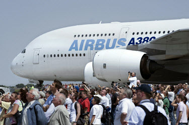 Visitors to the International Aviation Exhibition, held at the Schoenefeld Berlin-Brandenburg airport, stand in front of the Airbus A380. Manufactured by the European corporation Airbus, an EADS subsi...