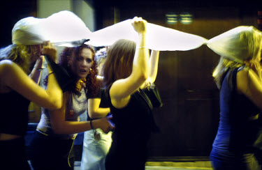 A Blackpool hen party sheltering themselves from the rain under a plastic sheet as they make their way to the next pub.