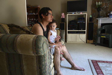 28 year old Danny Savalba, a Honduran immigrant, sits in his home in Manassas, Virginia with his one year old daughter Alison. His house has plummeted in value over the last year from 295,000 USD to 1...