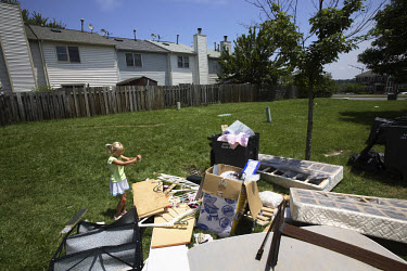A young girl plays beside a pile of discarded belongings outside a foreclosed house in Manassas, Virginia. The area is suffering from a major collapse in the housing market following the subprime cris...