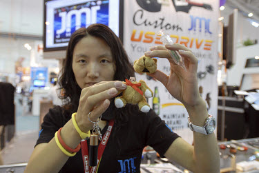 A sales rep shows various USB storage devices manufactured by her Mainland China company at the new Taipei World Trade Center Nangang Exhibition Hall, which hosted the COMPUTEX trade show. The show is...