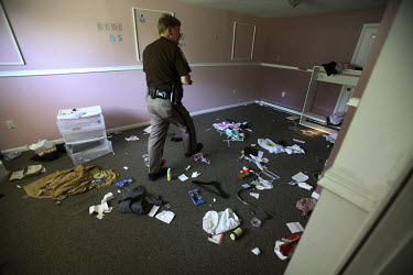 Deputy Rick Booth from the Manassas Sheriff Office in Virginia searches a foreclosed home. He found the house empty, but with the locks changed. The area is suffering from a major collapse in the hous...