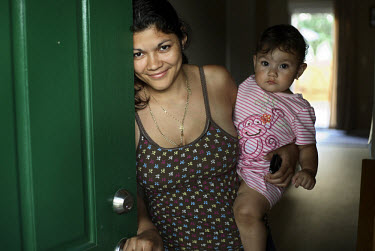 25 year old Elsie Savalba, a Honduran immigrant, stands in the doorway of her home in Manassas, Virginia with her one year old daughter Alison. Her house has plummeted in value over the last year from...