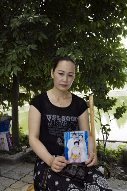 Wang Jinghui, aunt of 15 year old He Xue, holds a picture of her niece. She was killed by the Sichuan earthquake. Mrs Wang tells of how Mr He Shicai, grandfather of He Xue, died of grief when he heard...