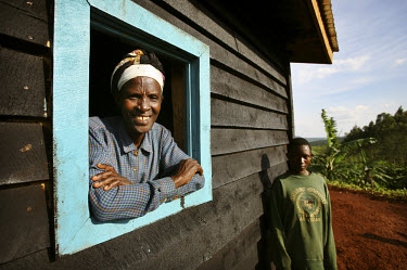 Valerie, who lost her husband and eight children in the 1994 genocide, stands at the window of her new home that was built by Rwanda Aid.