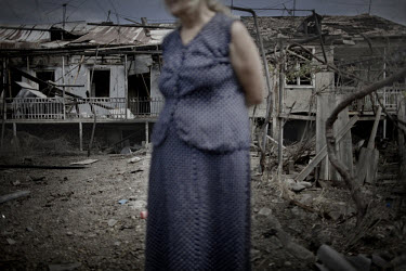 A woman stands in front of a destroyed house in the village of Tkviavi between the border of South Ossetia and Gori, an area still under the control of the Russian army.