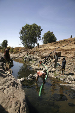 Farmers connect a small water pump to the river as part of a small scale irrigation project to provide water for potatoes. IFAD (International Fund for Agricultural Development) are currently involved...