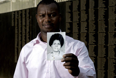 Freddy Mutangula holds a picture of his sister who was killed during the 1994 genocide, at the Kigali Memorial.
