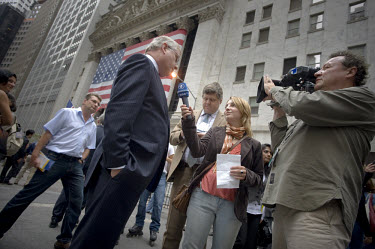 A Wall Street banker is interviewed outside the New York Stock Exchange (NYSE) on the day when share prices plummeted after the US Government failed to reach an agreement to bail out the country's ail...