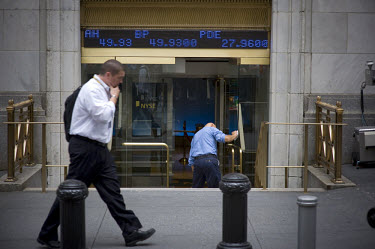 A Wall Street banker walks past the New York Stock Exchange (NYSE) on the day when share prices plummeted after the US Government failed to reach an agreement to bail out the country's ailing financia...