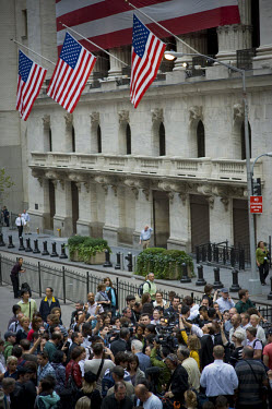 A crowd gathers on Wall Street outside the New York Stock Exchange (NYSE) on the day when share prices plummeted after the US Government failed to reach an agreement to bail out the country's ailing f...