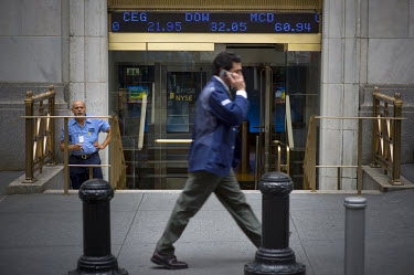 A Wall Street banker walks past the New York Stock Exchange (NYSE) on the day when share prices plummeted after the US Government failed to reach an agreement to bail out the country's ailing financia...