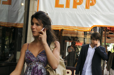 Mobile phone users in the fashionable Left Bank district of St Germain des Pres, which has many famous cafes, including Brasserie Lipp, one of the city's most famous restaurants.