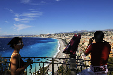 Tourists looking at the view over Nice and its pubic beaches facing onto the Mediterranean. Nice is the largest city on the French Riviera (Cote d'Azur).