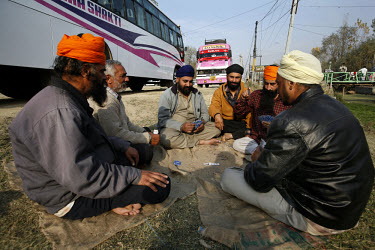 Sikh tourists play cards whilst being stranded for two days outside Srinagar due to paramilitary police enforcing a curfew imposed to stop separatists gathering for a political demonstration.