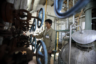 A worker adjusts a series of valves during production at China Clean Energy Inc. The company recycles waste cooking oil products into precursor materials that will eventually make bio-desiel, epoxies,...