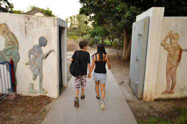 A young couple take a walk into the Degania Kibbutz, the first Israeli kibbutz, founded in 1910 by Russian immigrants.
