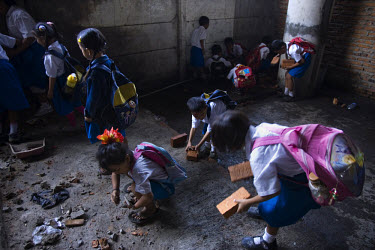 Young children help carry bricks and stones to the new site of the Kartini Emergency School. In September 2007 city authorities evicted the school from its location under a North Jakarta highway. Unda...