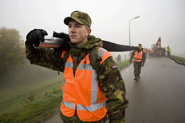 An army unit covers a dike with tarpaulin along the river Rhine, during heavy fog, to protect it from high water. All over the Netherlands, the authorities are practicing their emergency response to a...