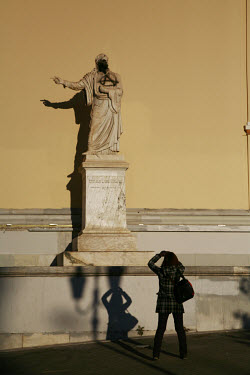 A young Athenian takes a picture of a statue painted with an anarchist symbol at Propylaia in central Athens. Mass demonstrations and riots spread throughout the country after police shot dead 15 year...