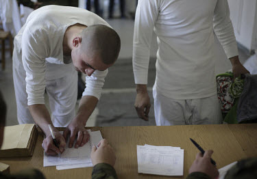 A new conscript signing papers as he leaves his belongings on deposit. This year's class of drafted recruits is the final one after 90 years of compulsory military service, as Poland's army turns prof...